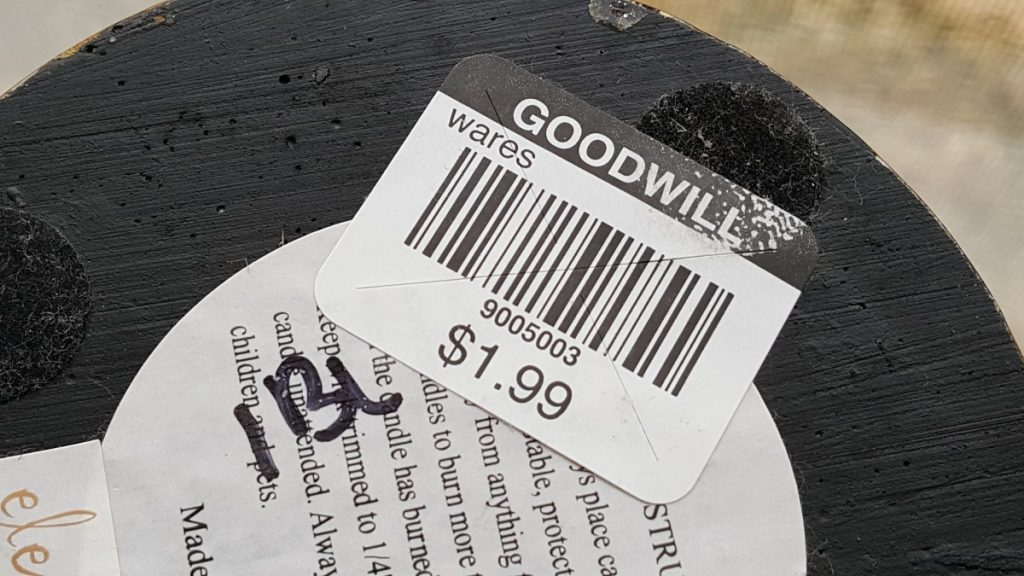 Black Goodwill Price tag at $1.99 and handwritten in black marker 1BL Purple Monkey Manor